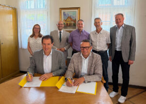 Stiegeler-Geschäftsführer Felix Stiegeler und Bürgermeister Michael Schlecht (vorne, v.l.n.r.) unterzeichnen den Zuwendungsvertrag in Beisein von Chrysiida Angelopoulou von der Gigabit Region Stuttgart, Landrat Marcel Musolf, Schopflochs Ortsvorsteher Gunter Berger, Gutenbergs Ortsvorsteher Harald Röhner und dem Geschäftsführer des Zweckverbands Breitbandversorgung Landkreis Esslingen Markus Grupp (hinten, v.l.n.r.). (Foto: Stiegeler)