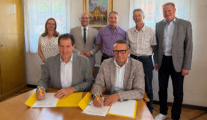 Stiegeler-Geschäftsführer Felix Stiegeler und Bürgermeister Michael Schlecht (vorne, v.l.n.r.) unterzeichnen den Zuwendungsvertrag in Beisein von Chrysiida Angelopoulou von der Gigabit Region Stuttgart, Landrat Marcel Musolf, Schopflochs Ortsvorsteher Gunter Berger, Gutenbergs Ortsvorsteher Harald Röhner und dem Geschäftsführer des Zweckverbands Breitbandversorgung Landkreis Esslingen Markus Grupp (hinten, v.l.n.r.). (Foto: Stiegeler)
